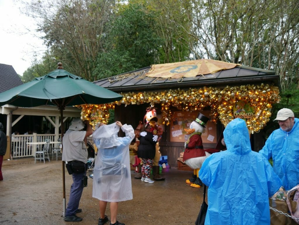 Characters under a hut decorated for Christmas, greeting guests